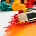 Close-up of paintbrushes with paint on canvas